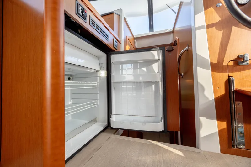 Smooth Yacht Photos Pics Open refrigerator inside 2019 Beneteau Swift Trawler 30, showcasing interior design and amenities.