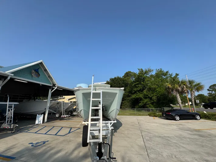  Yacht Photos Pics 2022 Invincible 40 Catamaran on trailer at a boat dealership under clear blue sky.