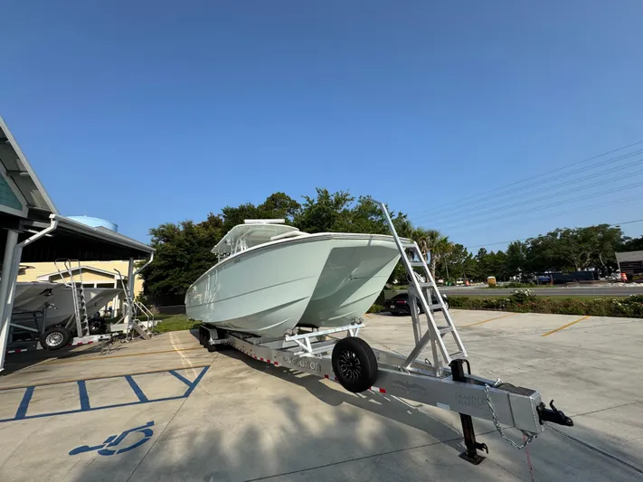  Yacht Photos Pics 2022 Invincible 40 Catamaran on trailer in parking lot, clear sky background.
