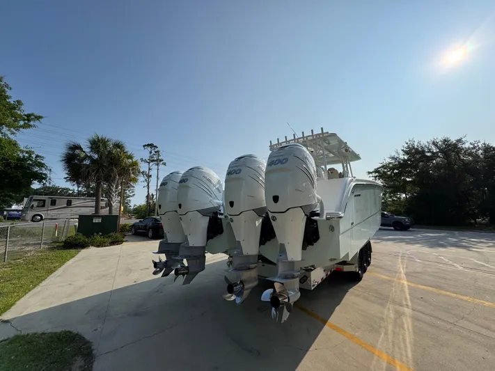  Yacht Photos Pics 2022 Invincible 40 Catamaran with triple outboard engines in a sunny parking lot.