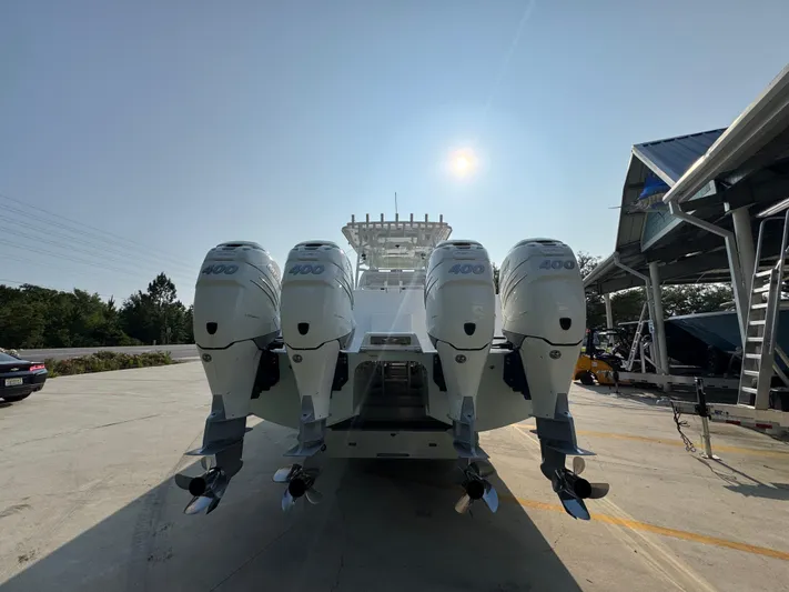  Yacht Photos Pics 2022 Invincible 40 Catamaran with four powerful outboard engines, docked under clear sky.