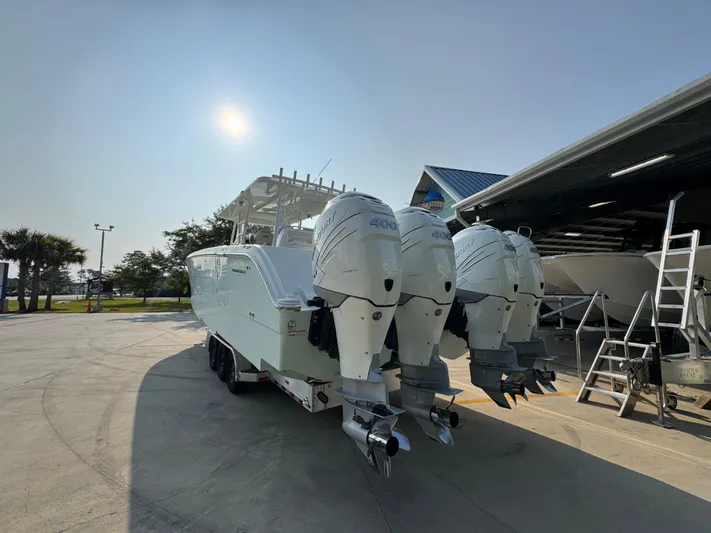  Yacht Photos Pics 2022 Invincible 40 Catamaran with triple outboard engines in a sunny marina setting.