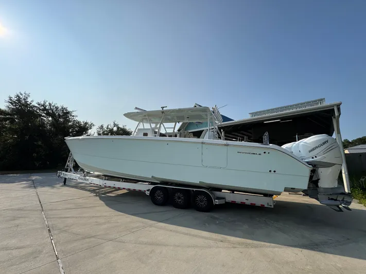  Yacht Photos Pics 2022 Invincible 40 Catamaran on trailer, parked outdoors under clear sky.