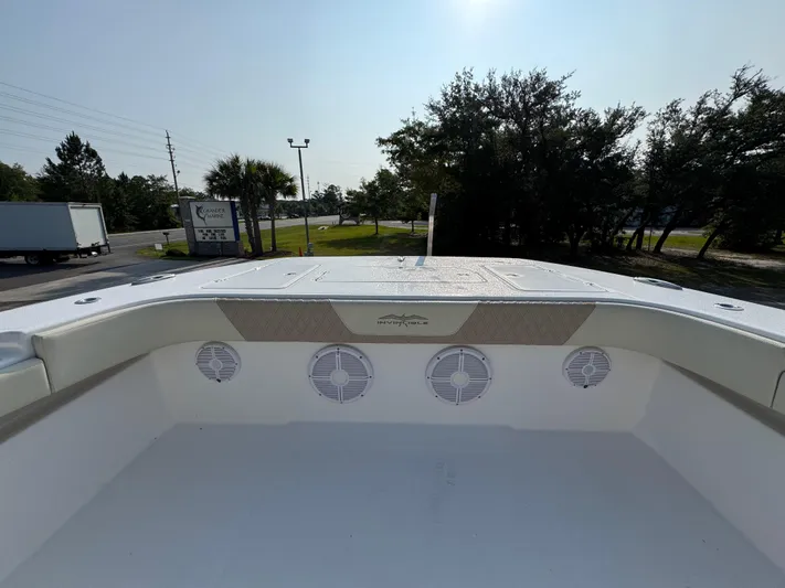  Yacht Photos Pics 2022 Invincible 40 Catamaran deck with speakers, surrounded by trees and road.