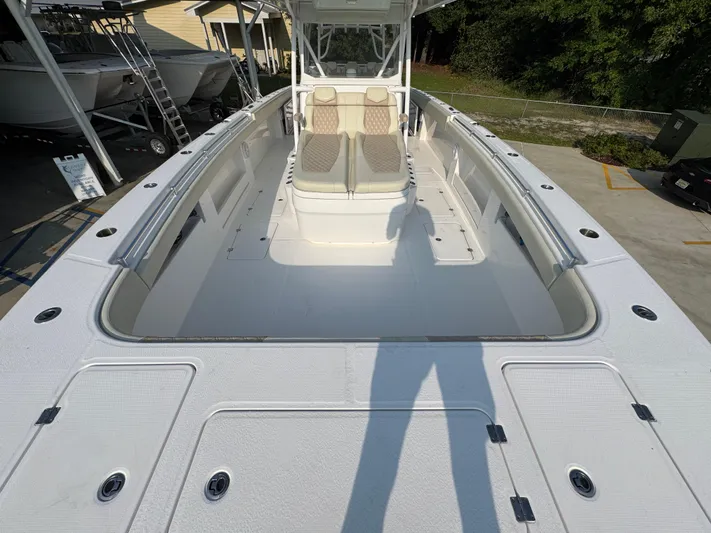  Yacht Photos Pics 2022 Invincible 40 Catamaran boat deck with seating, docked outdoors.