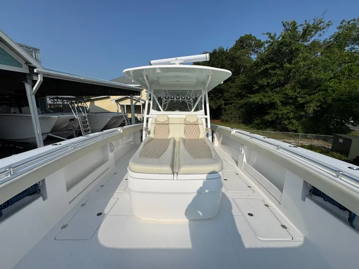  Yacht Photos Pics 2022 Invincible 40 Catamaran with spacious deck and seating, docked near trees.