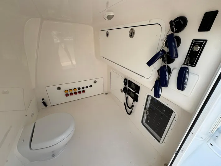  Yacht Photos Pics Invincible 40 Catamaran 2022 interior with toilet, control panel, and storage compartments.