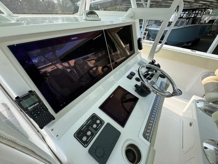  Yacht Photos Pics Control panel of 2022 Invincible 40 Catamaran with steering wheel and navigation screens.