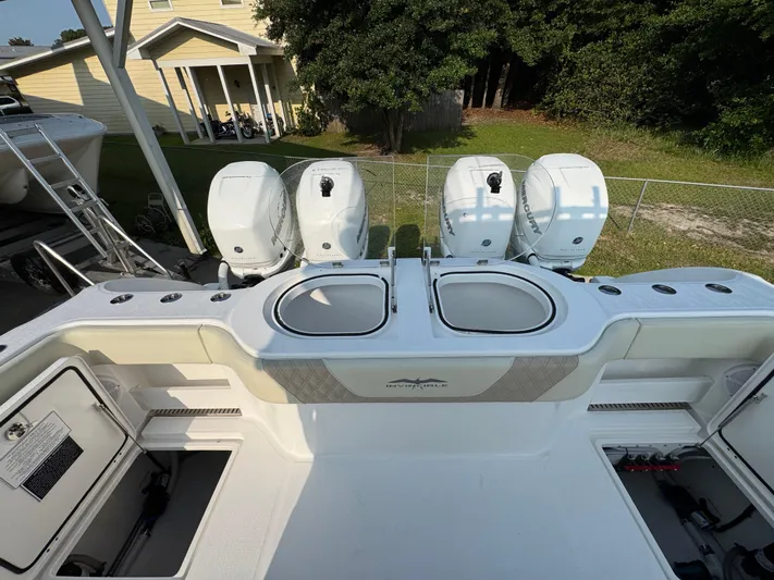  Yacht Photos Pics 2022 Invincible 40 Catamaran with four powerful outboard engines, docked near a house.