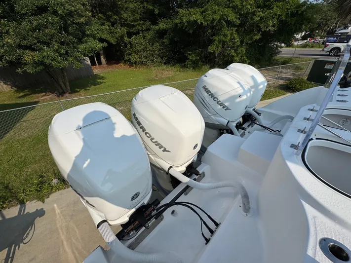  Yacht Photos Pics Triple Mercury outboard engines on a 2022 Invincible 40 Catamaran, parked outdoors.