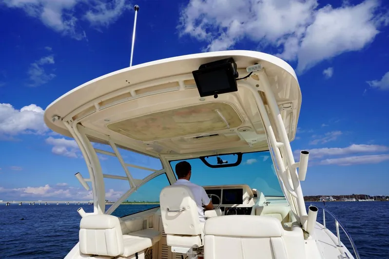  Yacht Photos Pics 2016 Grady-White Express 330 boat on water, clear sky, person at helm.