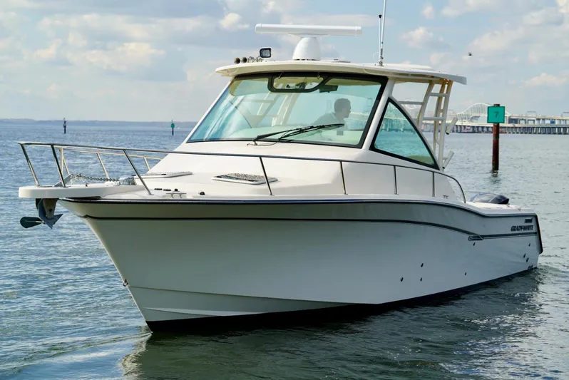  Yacht Photos Pics 2016 Grady-White Express 330 boat on calm water, showcasing sleek design and spacious cabin.