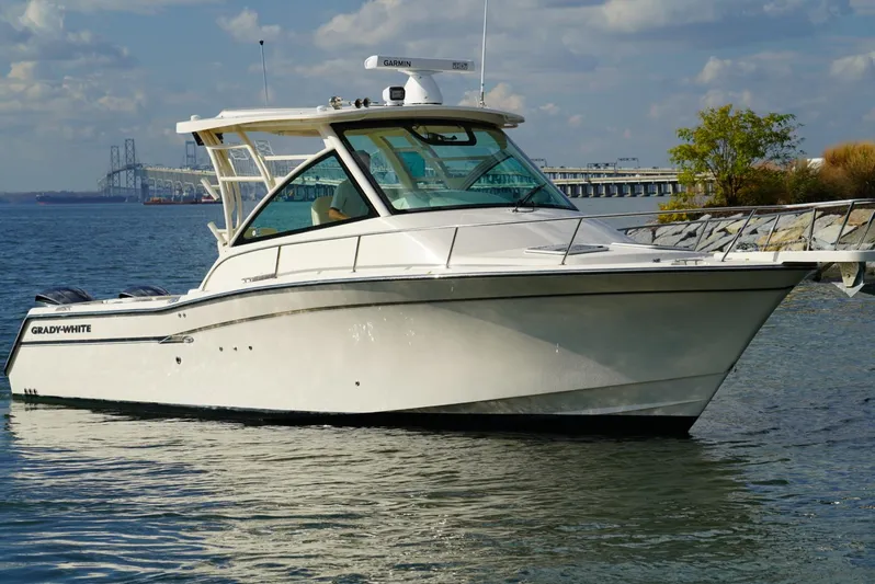  Yacht Photos Pics 2016 Grady-White Express 330 boat on calm water near a bridge and shoreline.