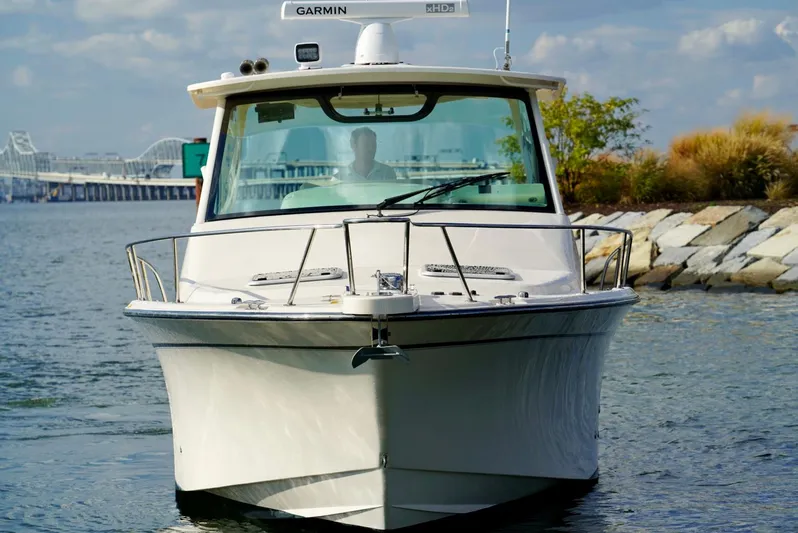  Yacht Photos Pics 2016 Grady-White Express 330 boat on water near rocky shoreline.