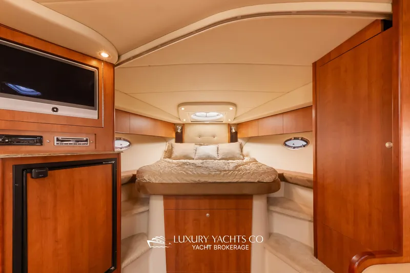  Yacht Photos Pics Luxurious 2009 Cruisers Yachts 360 Express cabin interior with wood finish and cozy bedding.