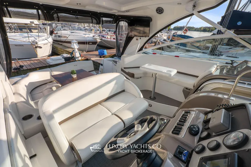  Yacht Photos Pics 2009 Cruisers Yachts 360 Express interior with helm, seating, and docked boats in background.