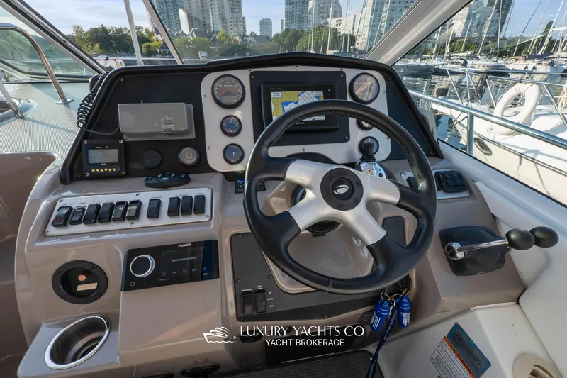  Yacht Photos Pics 2009 Cruisers Yachts 360 Express helm with navigation controls and city skyline view.