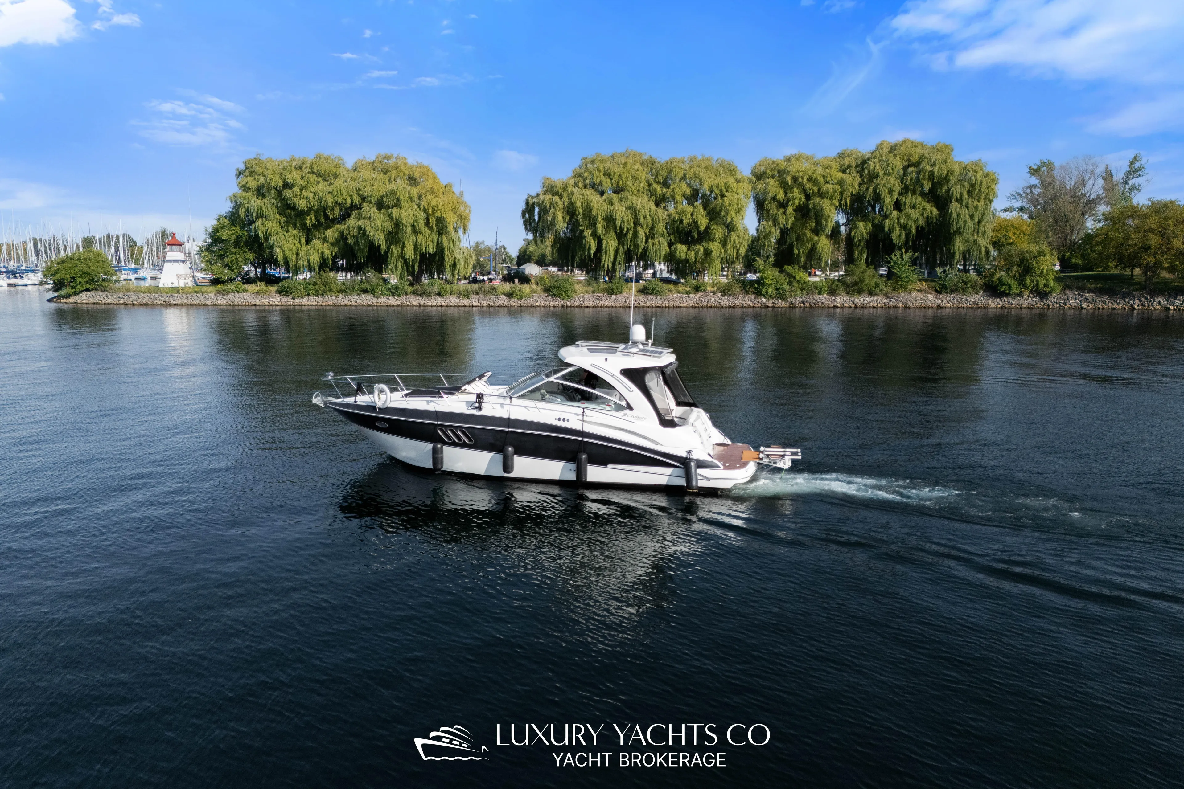  Yacht Photos Pics 2009 Cruisers Yachts 360 Express on serene water with lush green trees in the background.