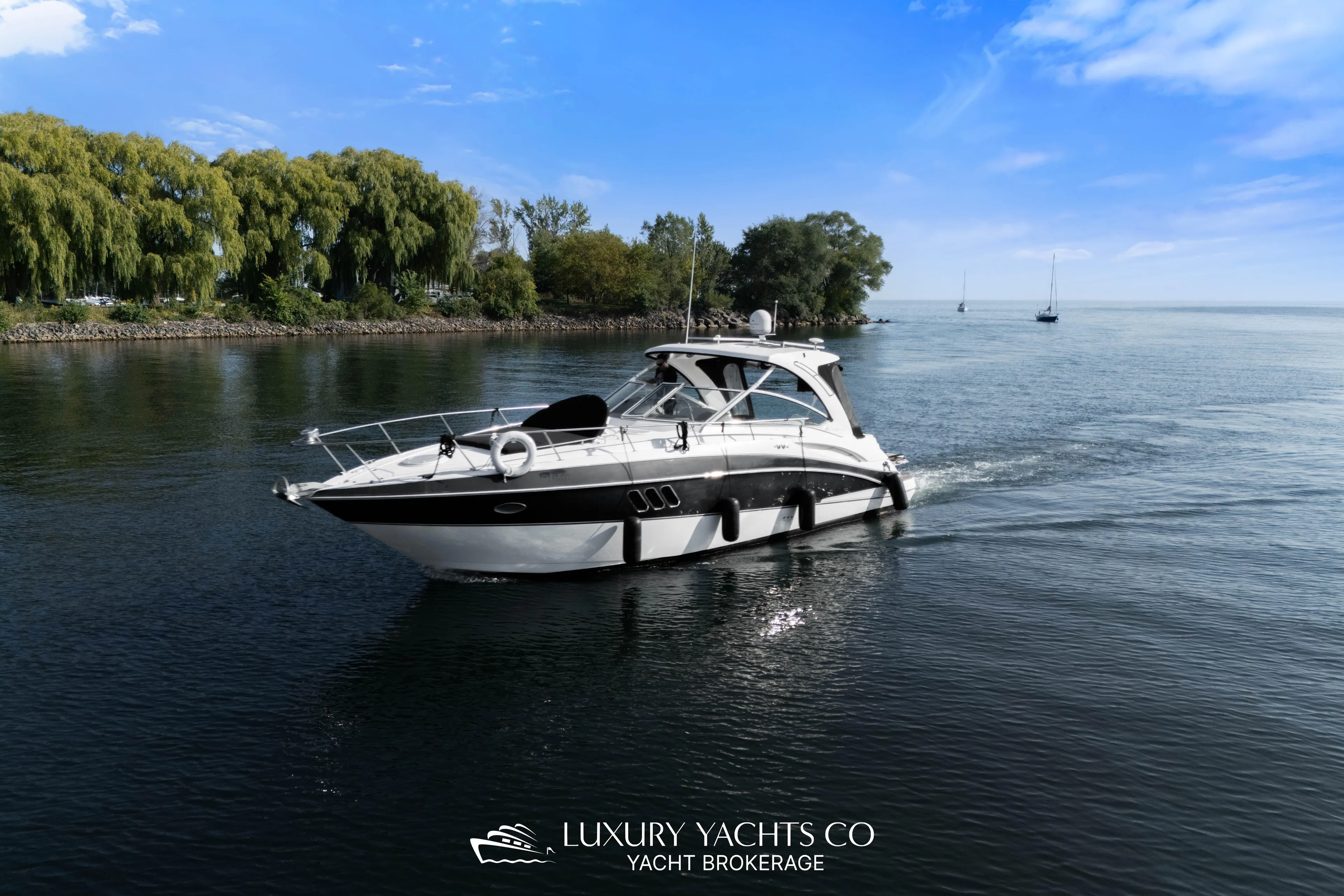  Yacht Photos Pics 2009 Cruisers Yachts 360 Express on serene water, surrounded by lush greenery and blue sky.