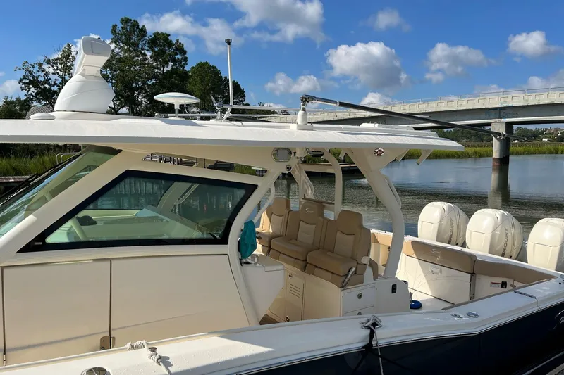  Yacht Photos Pics 2019 Scout 380 LXF boat docked by a scenic river with clear skies.