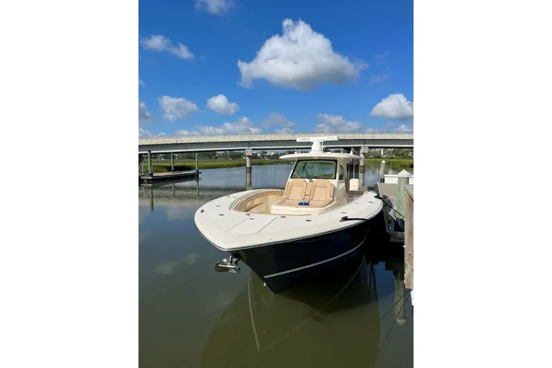  Yacht Photos Pics 2019 Scout 380 LXF boat docked on calm water under a blue sky.