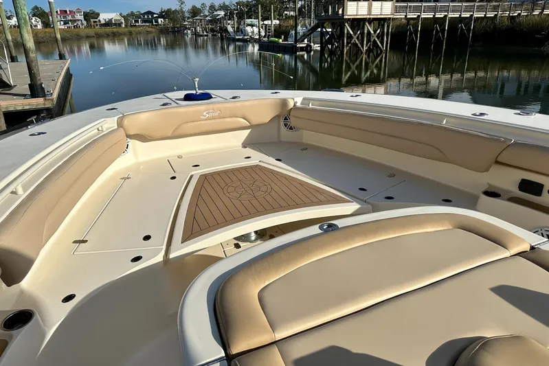  Yacht Photos Pics 2019 Scout 380 LXF boat interior with beige seating and wooden deck, docked by calm water.