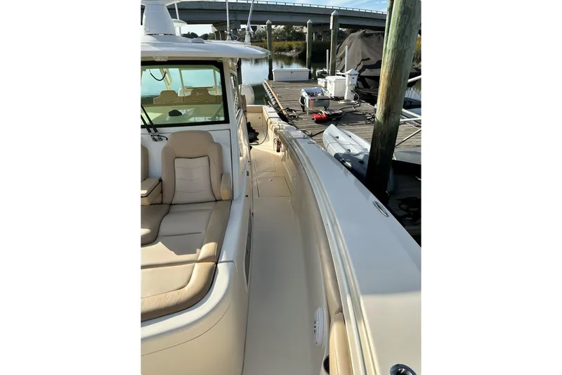  Yacht Photos Pics 2019 Scout 380 LXF boat docked, featuring beige seating and sleek design.