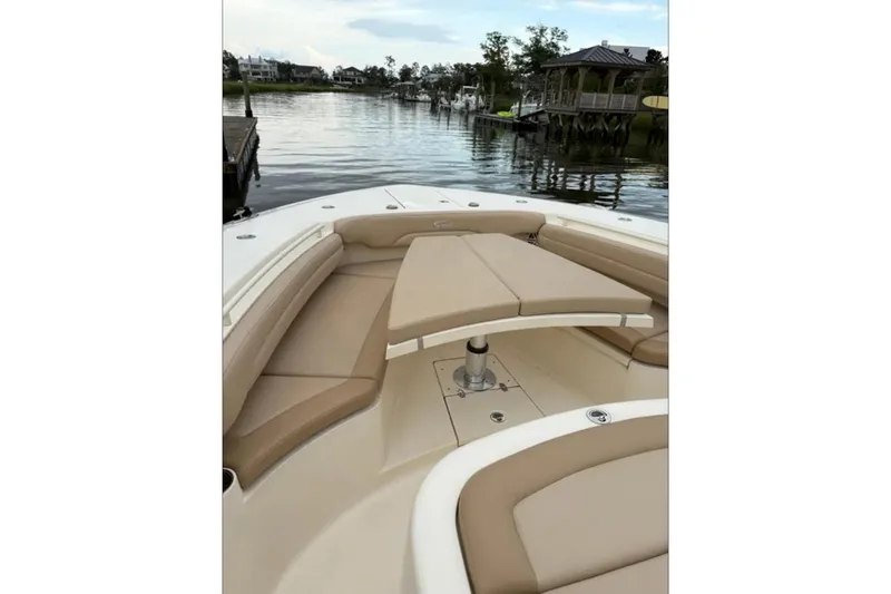  Yacht Photos Pics 2019 Scout 380 LXF boat with tan seating, docked by a serene waterfront.