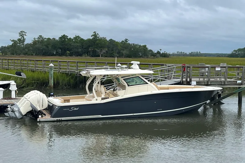  Yacht Photos Pics 2019 Scout 380 LXF boat docked by a wooden pier on a cloudy day.