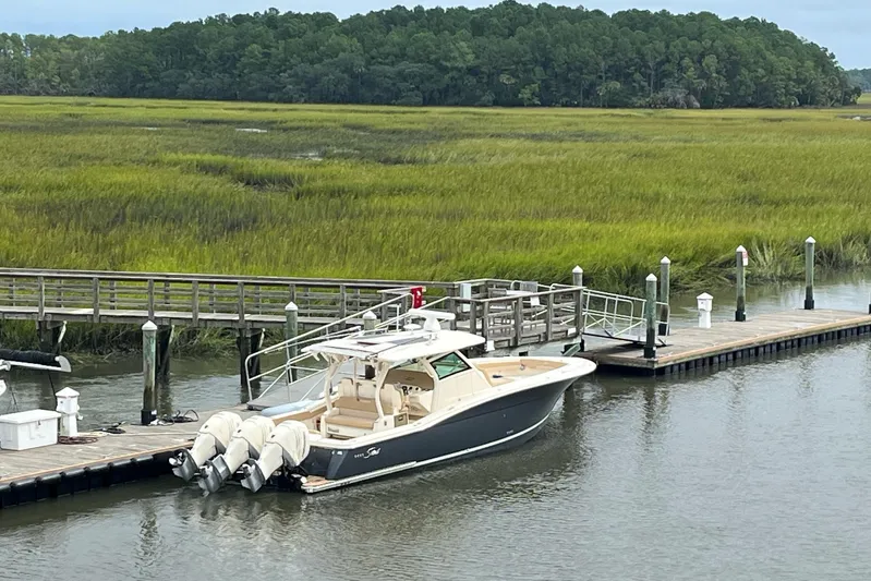  Yacht Photos Pics 2019 Scout 380 LXF boat docked by a scenic marshland.