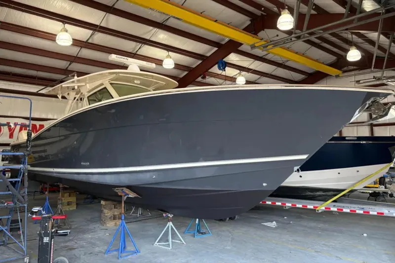  Yacht Photos Pics 2019 Scout 380 LXF boat in a warehouse, elevated on stands.