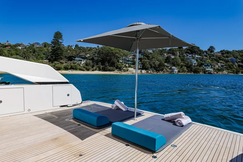 Donnachaidh Yacht Photos Pics Sanlorenzo SX76 yacht deck with sun loungers and umbrella, 2020 model, on serene water.