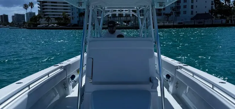  Yacht Photos Pics 2022 Contender 39 ST boat cruising on clear blue water near cityscape.