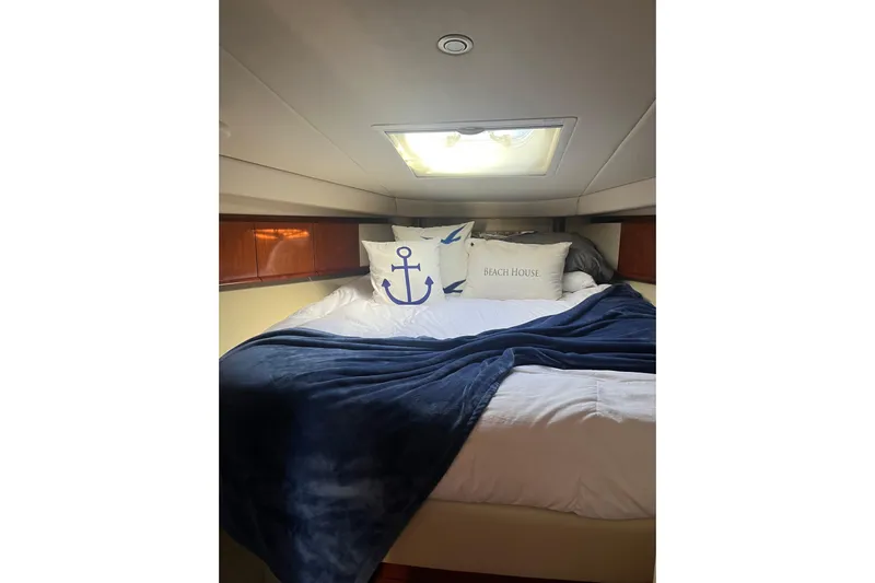  Yacht Photos Pics Cozy cabin interior of 2005 Sea Ray 390 Express Cruiser with nautical-themed bedding.