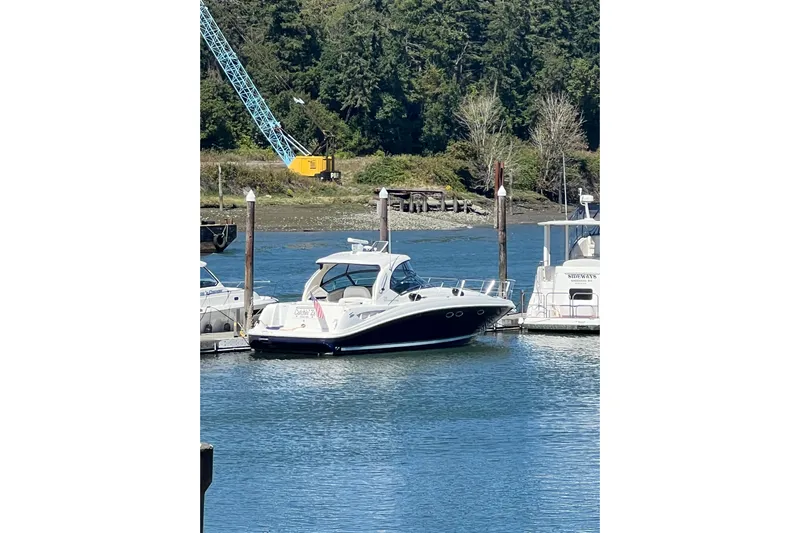  Yacht Photos Pics 2005 Sea Ray 390 Express Cruiser docked in a serene marina setting.