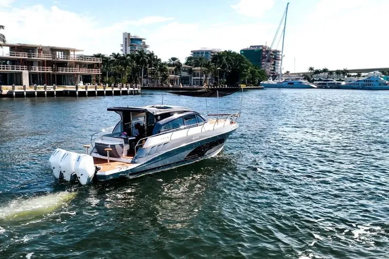  Yacht Photos Pics 2025 Hanover 415 boat cruising in a marina with modern buildings in the background.