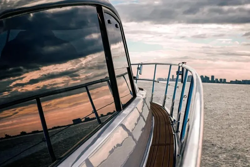  Yacht Photos Pics Modern Hanover 415 yacht reflecting sunset on water, city skyline in background, 2025 model.