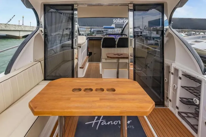  Yacht Photos Pics Interior of 2025 Hanover 415 yacht with wooden table and seating area.