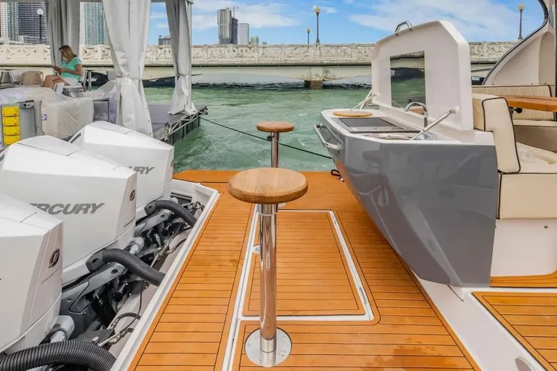  Yacht Photos Pics Luxury Hanover 415 yacht deck with Mercury engines, 2025 model, docked by a scenic bridge.