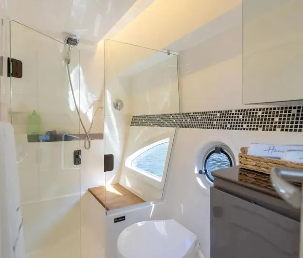  Yacht Photos Pics Modern bathroom in 2025 Hanover 415 yacht with shower, toilet, and porthole window.