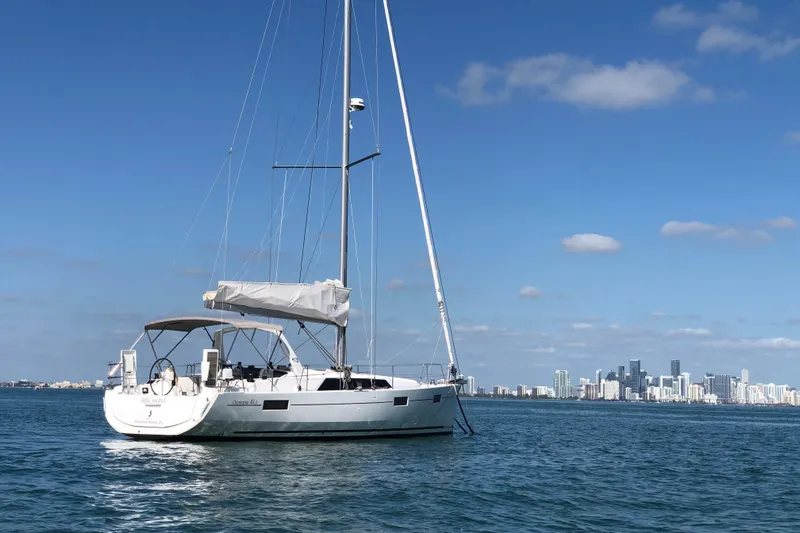 Deli Mavi Yacht Photos Pics 2019 Beneteau Oceanis 41.1 sailboat on calm water with city skyline in background.