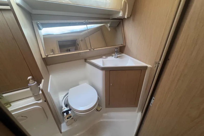 Deli Mavi Yacht Photos Pics 2019 Beneteau Oceanis 41.1 yacht bathroom with sink, mirror, and toilet.