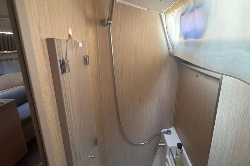 Deli Mavi Yacht Photos Pics Bathroom interior of 2019 Beneteau Oceanis 41.1 yacht with shower and wooden paneling.