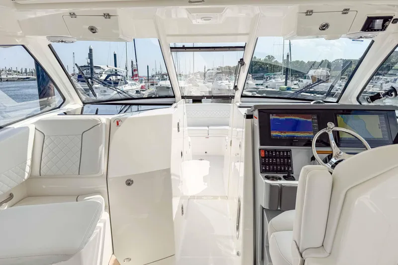  Yacht Photos Pics 2024 Pursuit DC 365 Dual Console interior with modern helm, luxurious seating, and marina view.
