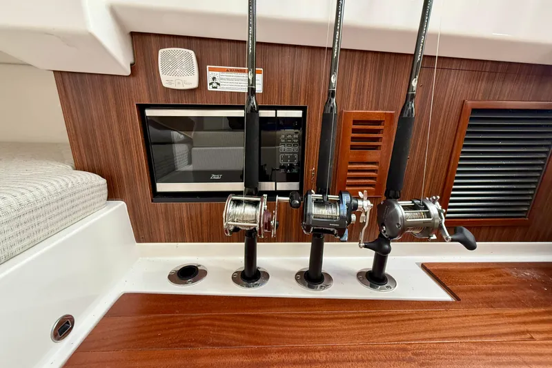 Yacht Photos Pics 2024 Pursuit DC 365 Dual Console interior with fishing rods and microwave.