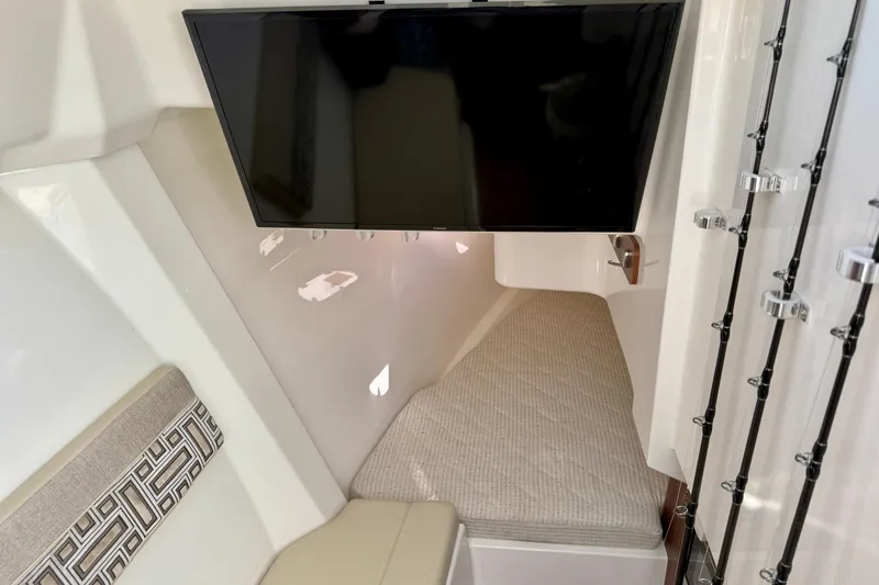  Yacht Photos Pics 2024 Pursuit DC 365 Dual Console cabin interior with TV and cushioned seating.