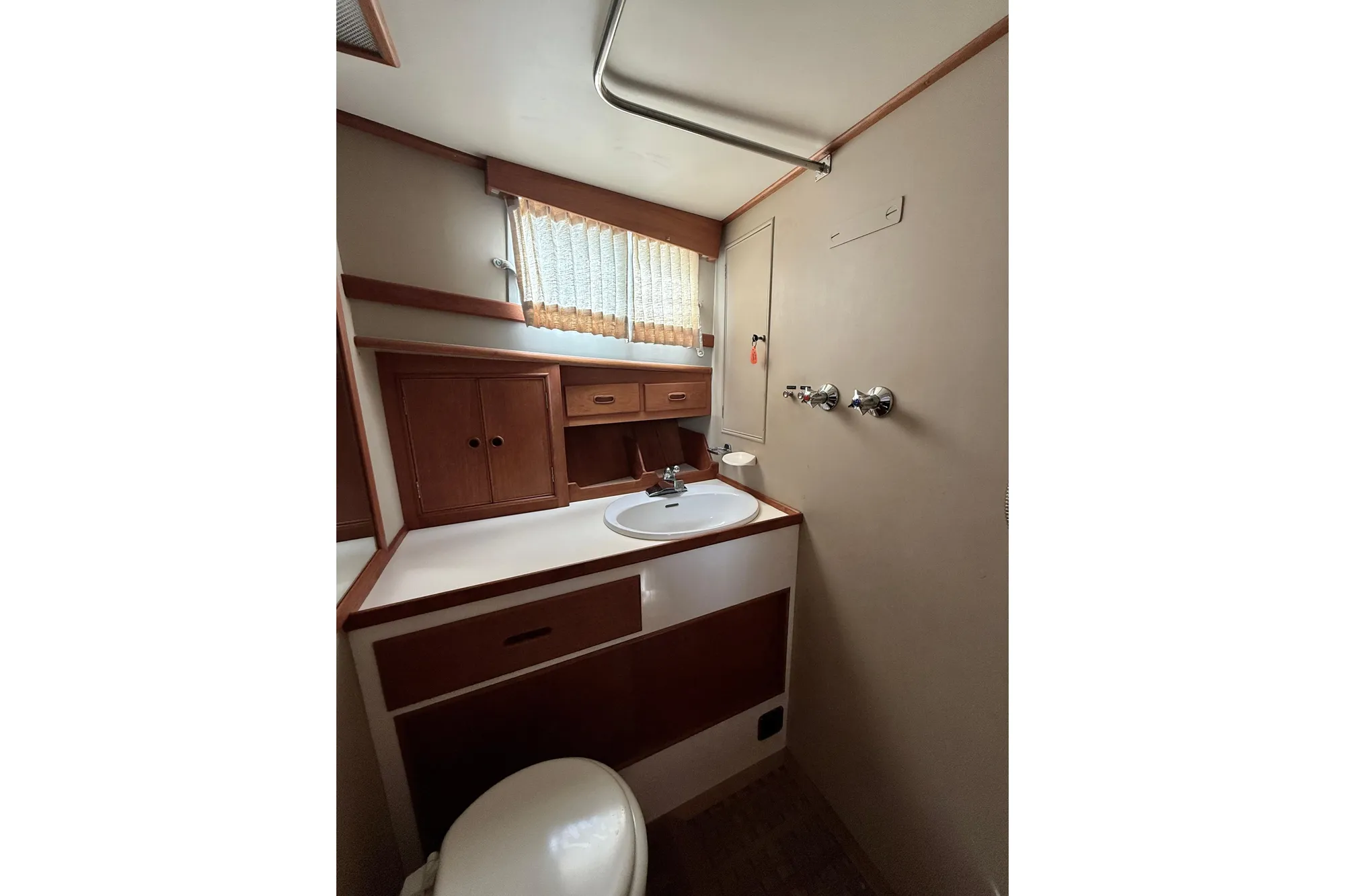 1982 Grand Banks 42 Classic yacht bathroom with wooden cabinets and sink.