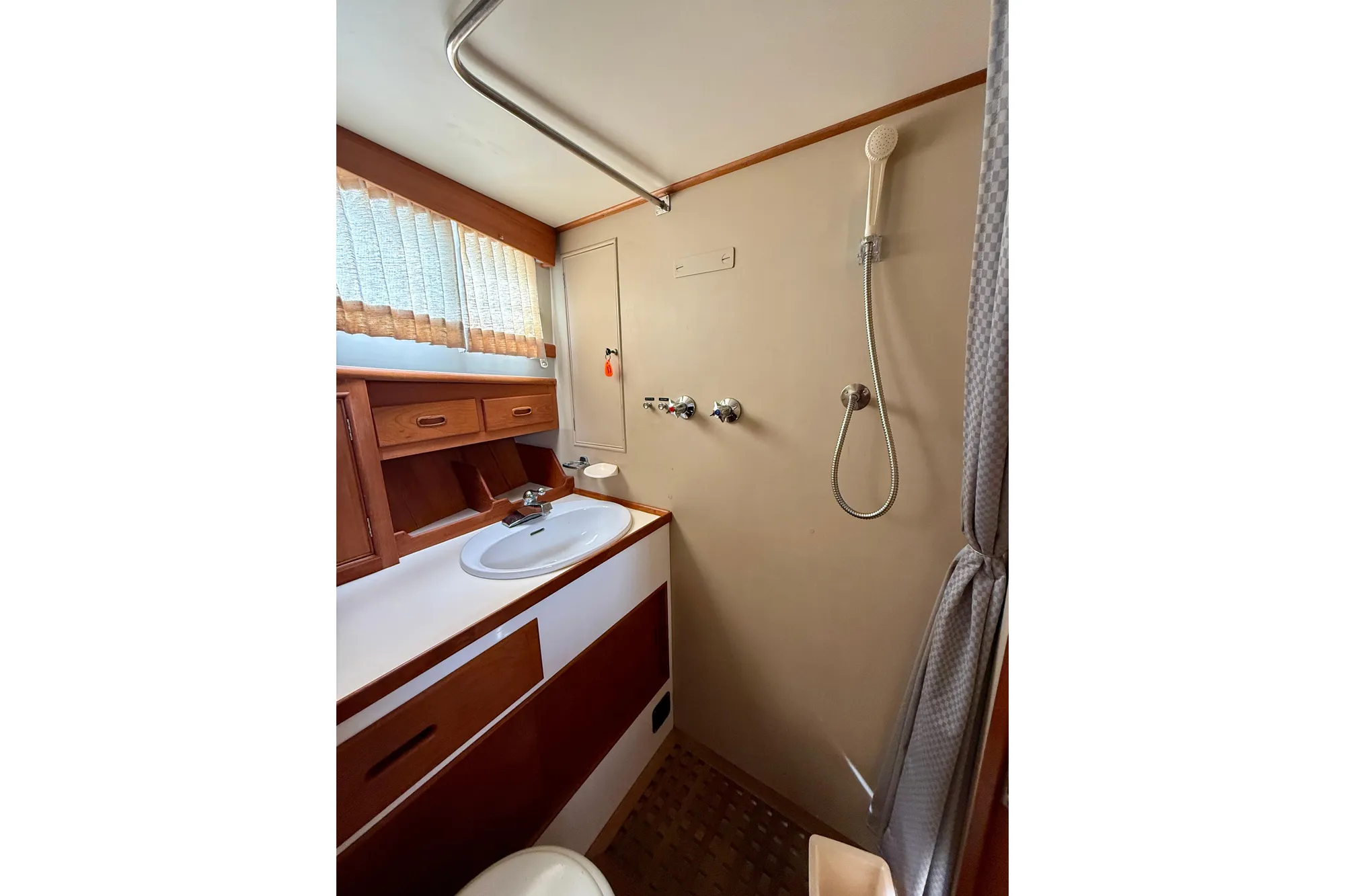 Bathroom interior of 1982 Grand Banks 42 Classic yacht with shower and sink.