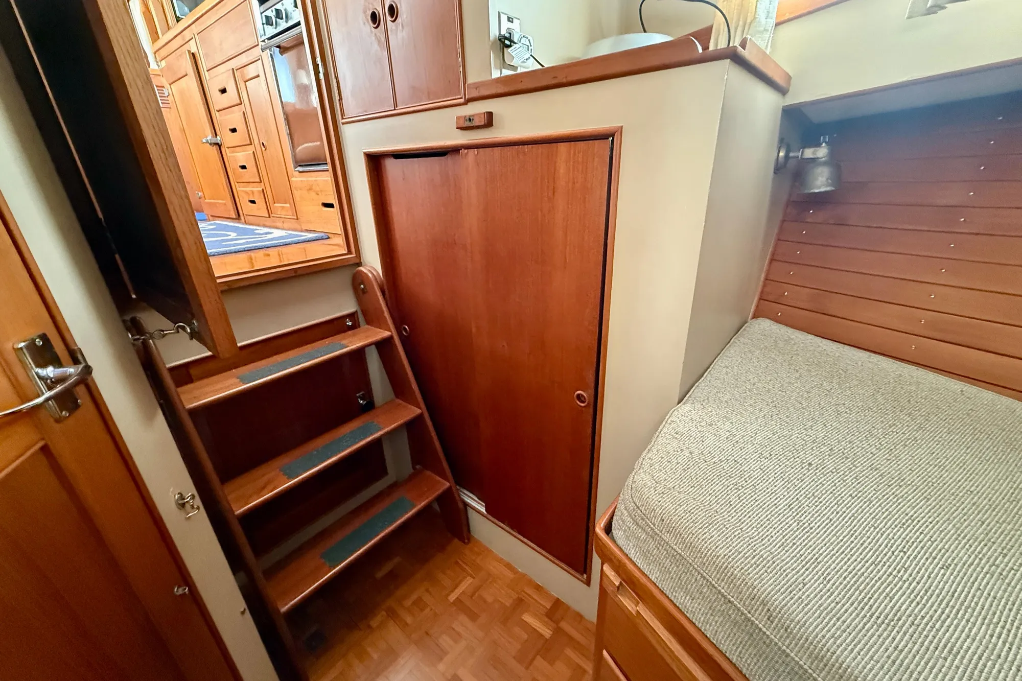 1982 Grand Banks 42 Classic interior with wooden stairs and cozy cabin bed.