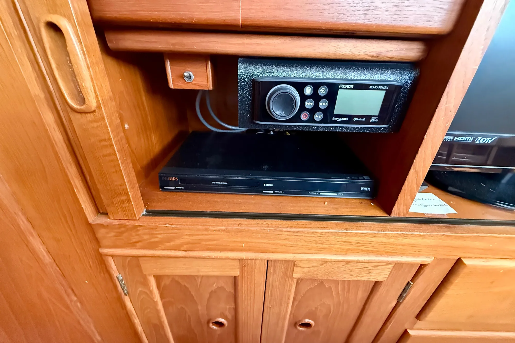 Wooden cabinet with audio system and DVD player on a 1982 Grand Banks 42 Classic yacht.